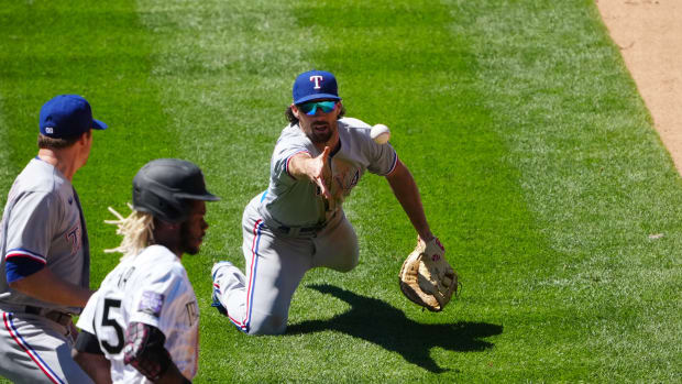 Jun 3, 2021; Denver, Colorado, USA; Texas Rangers infielder Charlie Culberson (2) fields the ball at relief pitcher Wes Benjamin (63) in the fifth inning against the Colorado Rockies at Coors Field.